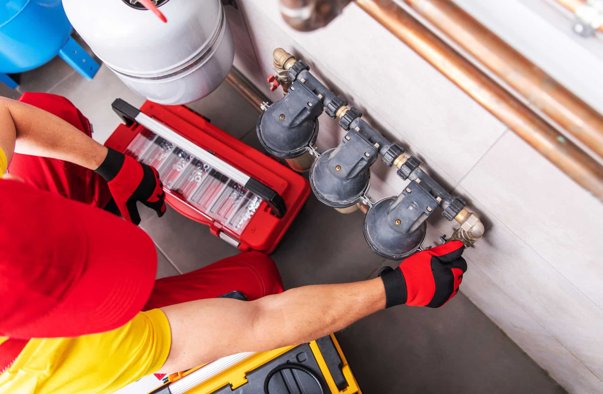 Professional plumber performing regular residential building water filters maintenance, Water filtration service.